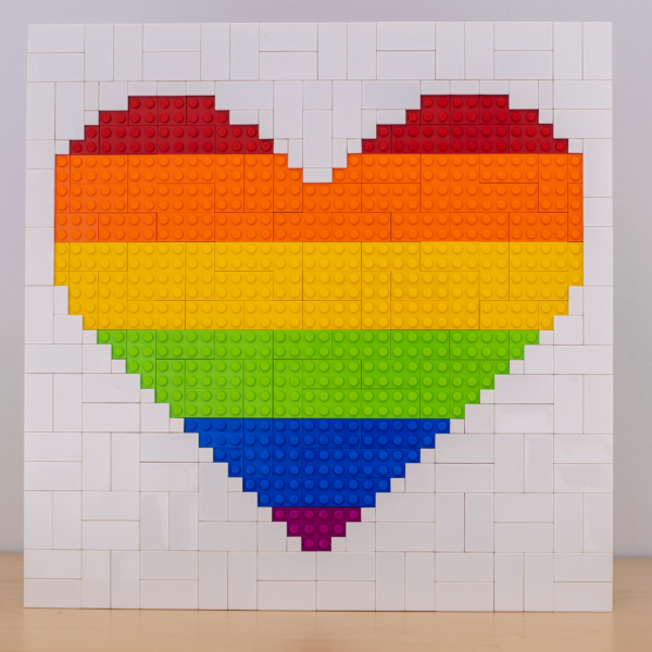 Ein Herz aus Klembausteinen dessen Farben die Pride Flagge bilden.